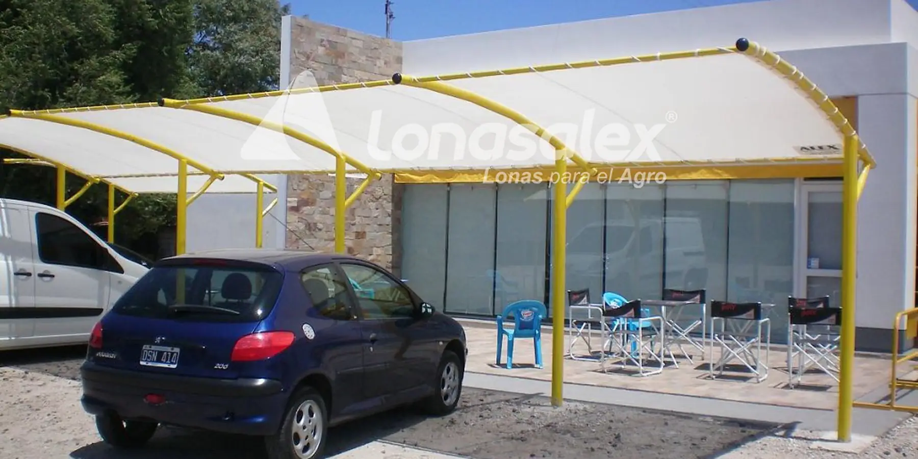 Estacionamiento cubierto con lona sobre estructura amarilla