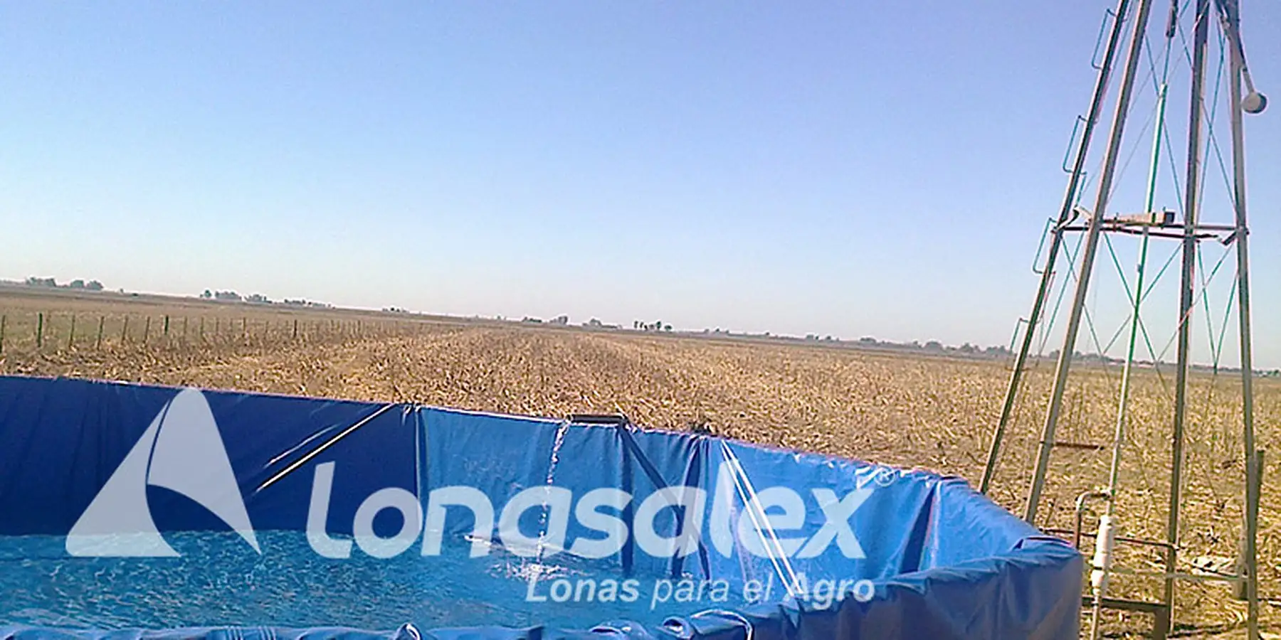 Tanque australiano con funda de lona azul, con un molino de fondo