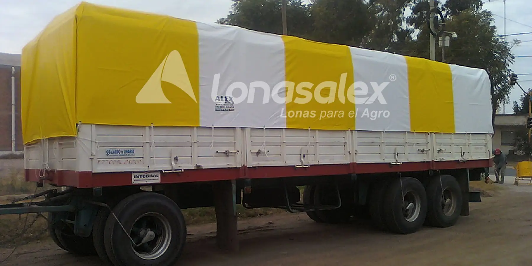 Camión con acoplado cubierto con lona amarilla y blanca a medida